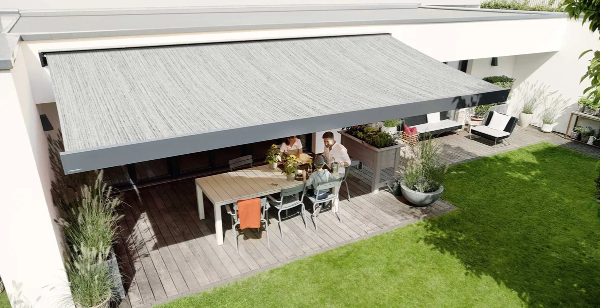 Tenda a bracci con telo grigio su terrazza