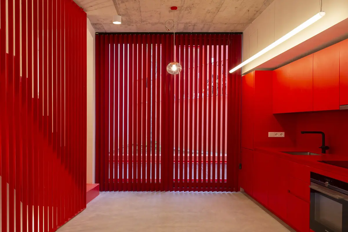 Cucina rossa con tende verticali coordinate
