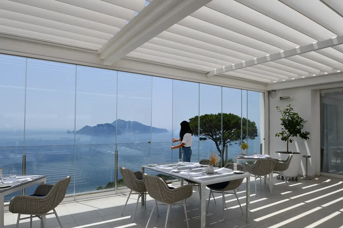 Pergola chiusa da vetrate scorrevoli su una terrazza vista mare